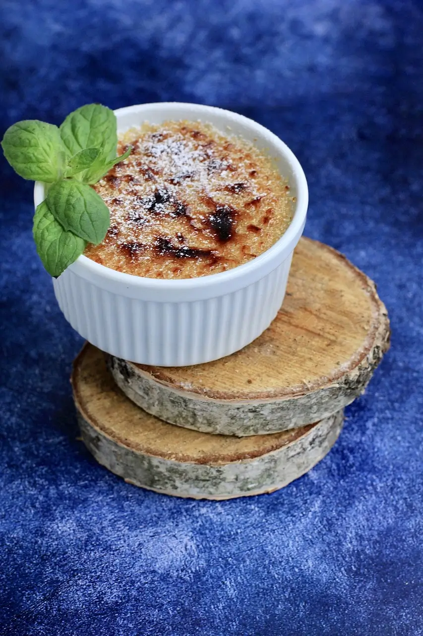 A crab brulee garnished with microgreens on a white plate.