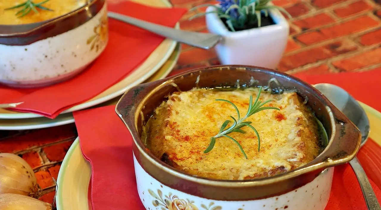  Close-up of a golden-brown crab brulee with a spoon beside it.